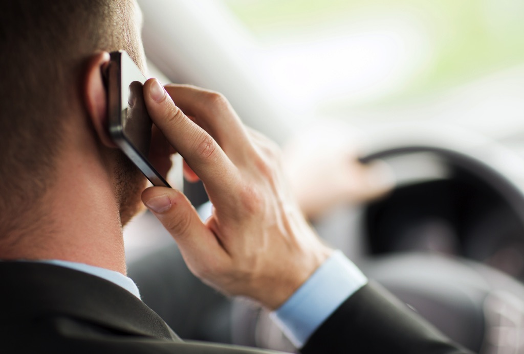 Hombre va manejando mientras habla por el celular