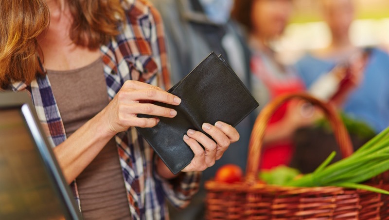 Mujer en el súper sacando su tarjeta de crédito