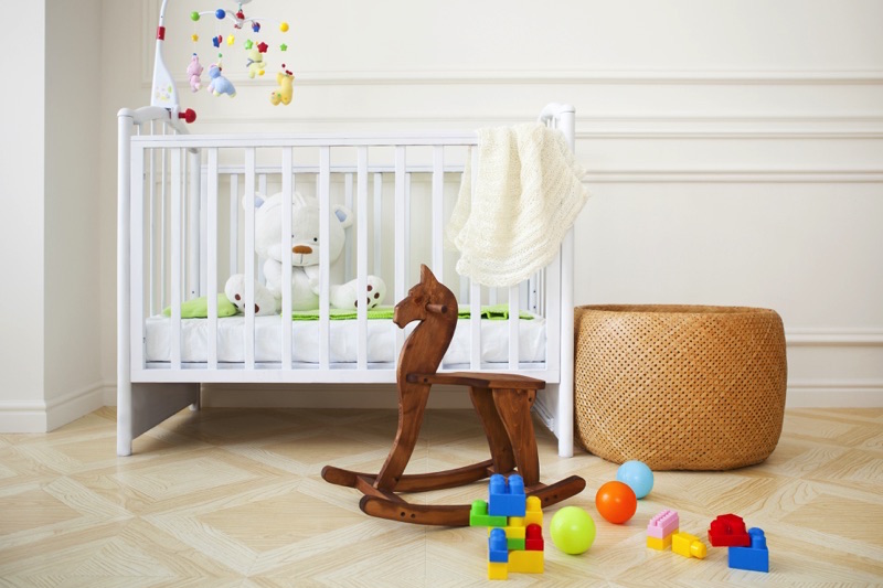 Cuarto de un bebé con cuna y un caballito de madera