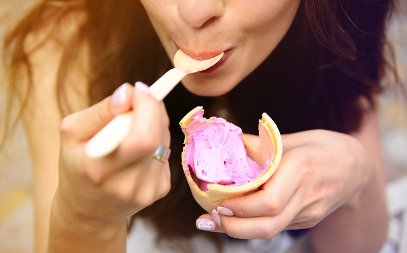 Mujer comiendo una nieve de fresa