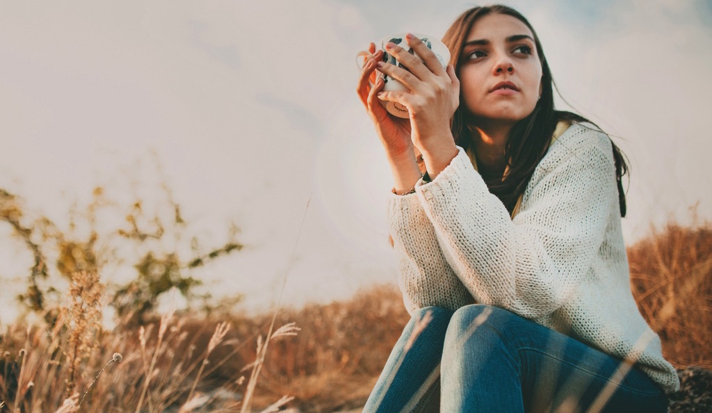 Mujer reflexionando en un campo