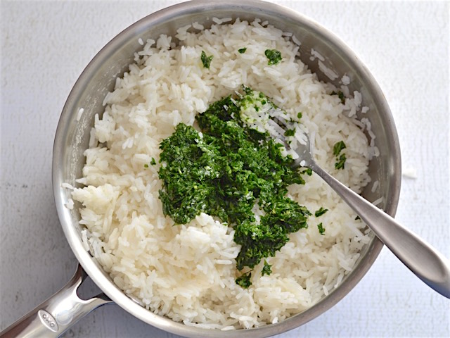 Una vez que el arroz está cocido y enfriado un poco, añadir el perejil y la cáscara de limón y revolver cuidando que el calor del arroz no cocine las verduras