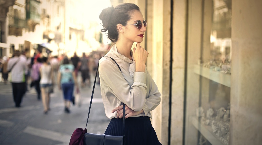 Chica viendo ropa en una vitrina