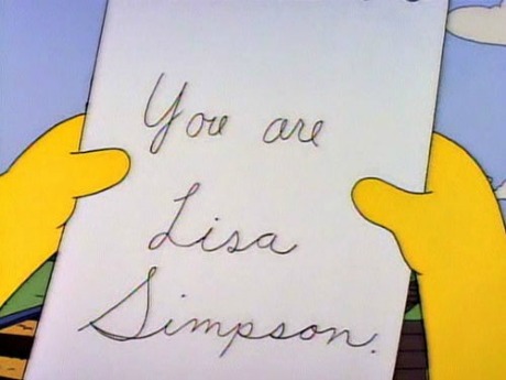 Escena de los Simpsons, persona sostiene un papel que dice: You are Lisa Simpson