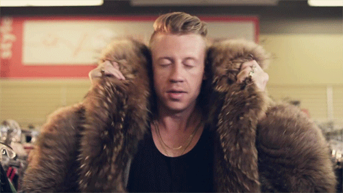 Macklemore poniendose un abrigo de piel