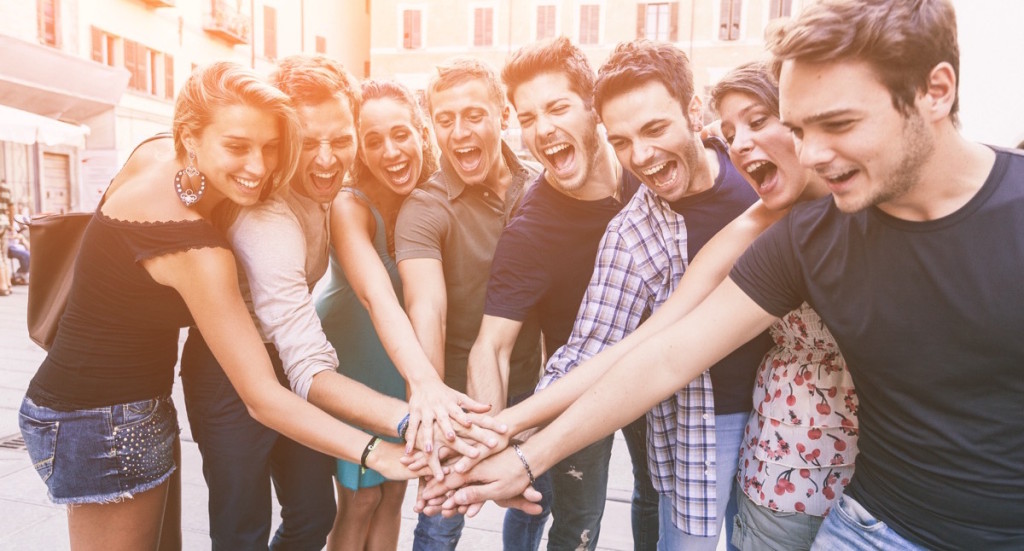 Grupo de amigos felices juntando las manos