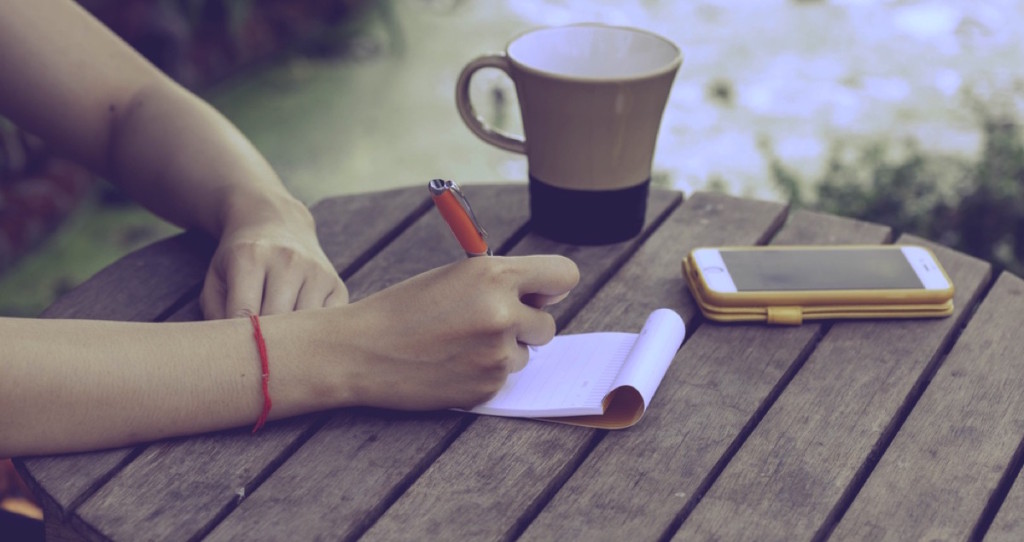 Mujer escribiendo una carta en una mesa