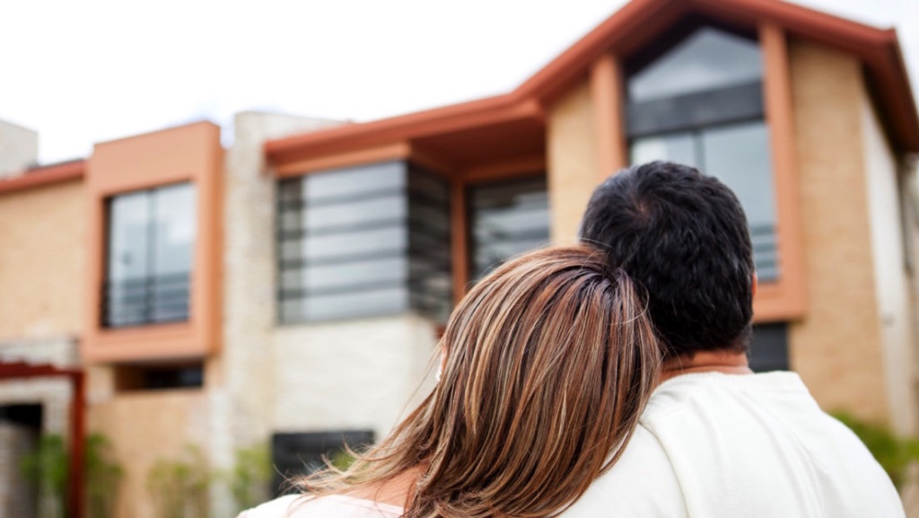 Pareja de espaldas viendo una casa