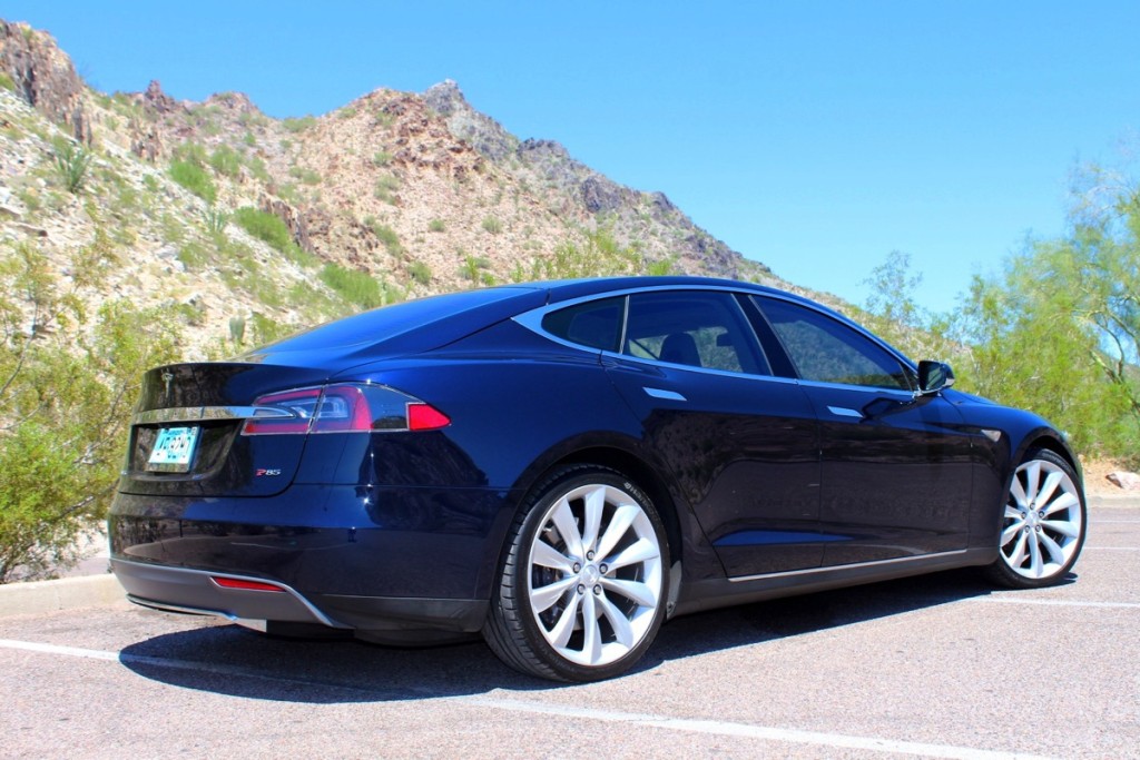 Parte posterior de un Tesla color azul en un fondo de montañas