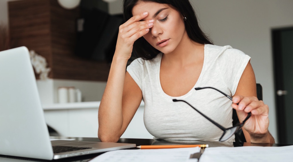 Mujer estresada frente a una laptop