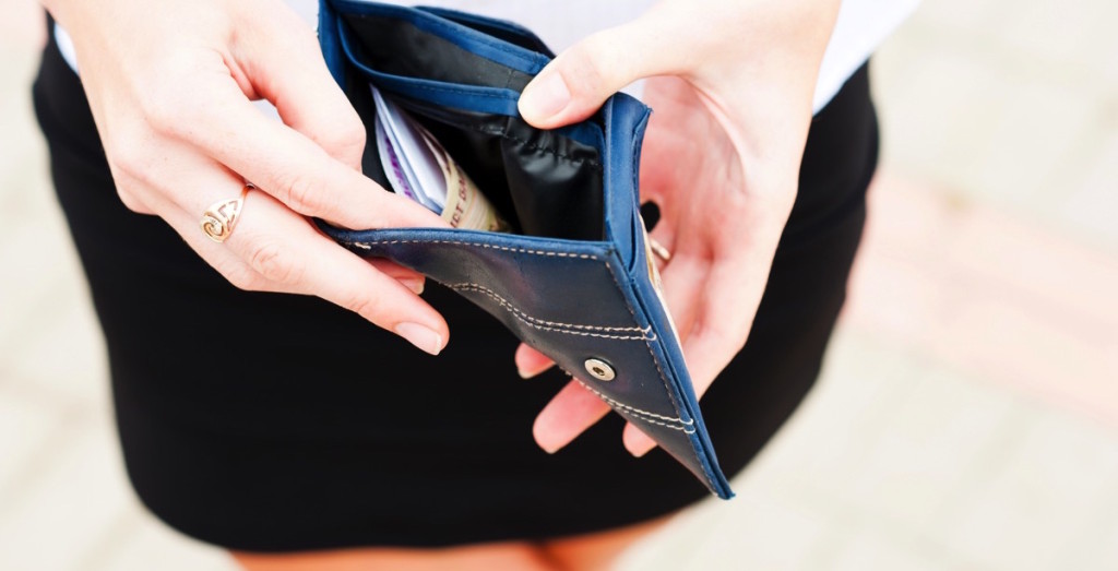 Mujer viendo su billetera con dinero