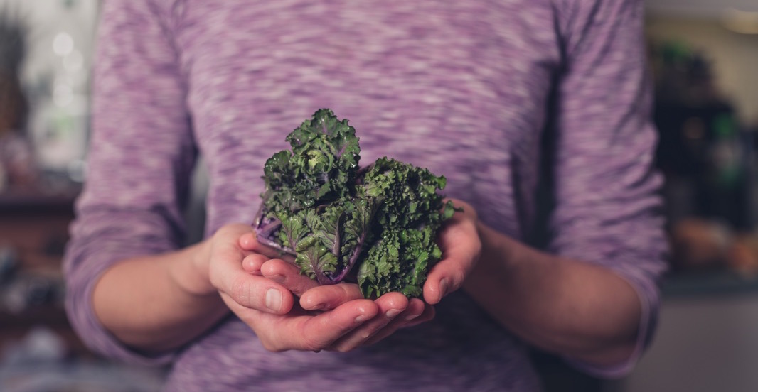 Mujer con brócoli cultivado en manos