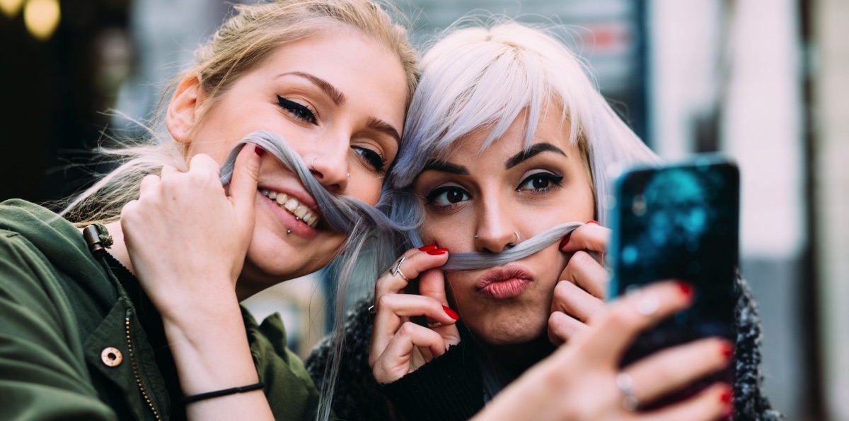 Amigas tomandose selfies con el celular