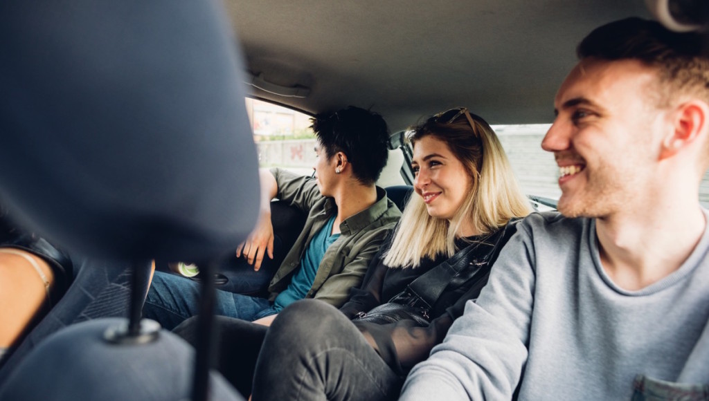 Un grupo de jóvenes compartiendo espacio en la parte trasera de un coche