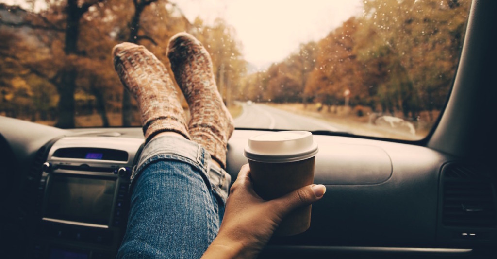 persona tomando café en su auto