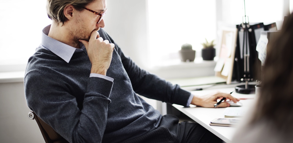 Hombre adulto con lentes y ropa formal casual en el trabajo con una mano en la carapensando 