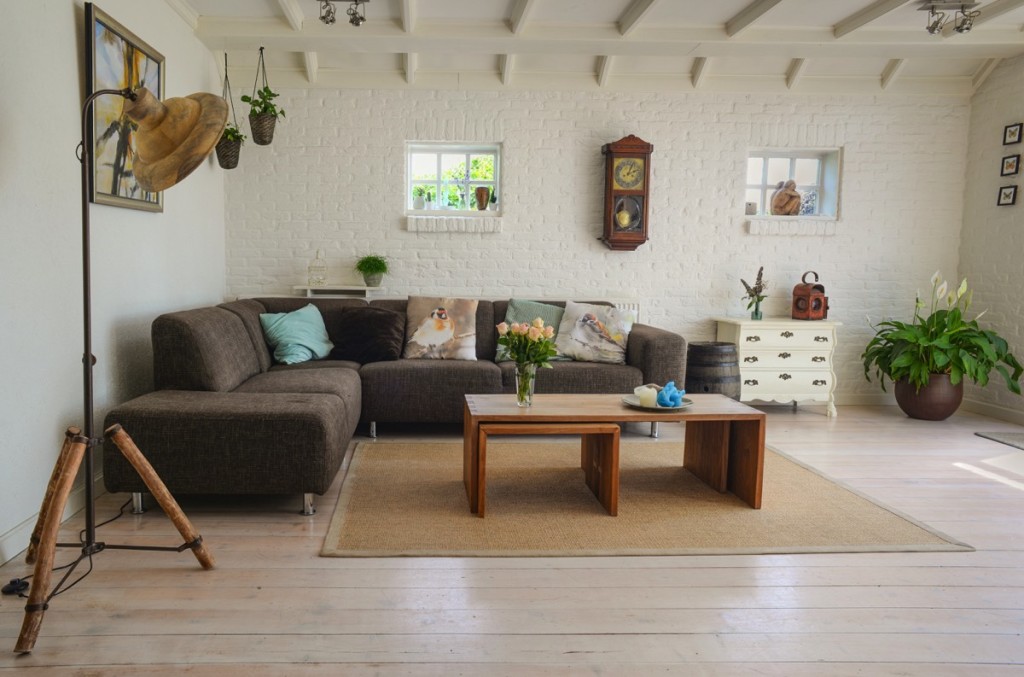 Sala de una casa, con sillón, mesa de madera y ventanas