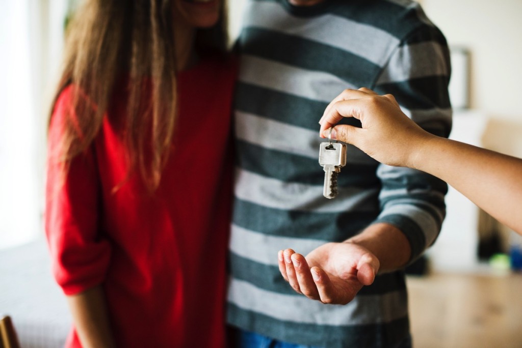 Pareja aceptando las llaves de una casa